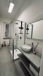 uma casa de banho com um lavatório e uma cabina de duche em vidro. em Birimari house em Arezzo
