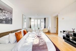 a bedroom with a large bed and a living room at 3-Bedroom Penthouse, Brentford, Free Parking in Brentford