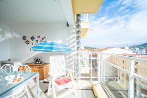 Un balcón con una mesa y sillas y una sombrilla. en Le Nautilus - Charmant apt proche de la plage, en Port-Vendres