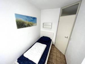 um pequeno quarto com uma cama e uma fotografia na parede em Schorrebloem 12 em Nieuwvliet
