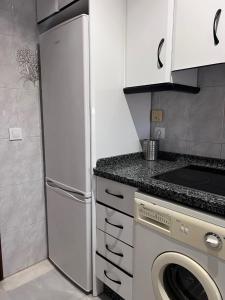 a kitchen with a refrigerator and a washing machine at Alojamientos María 2 in Seville