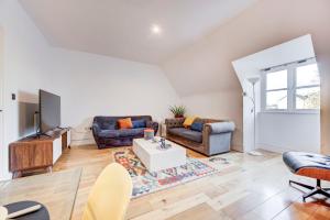 a living room with two couches and a tv at 3-Bedroom Penthouse, Brentford, Free Parking in Brentford