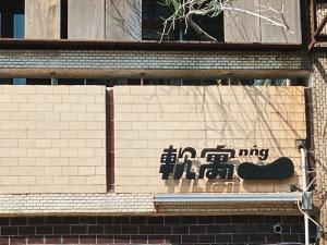 um sinal numa parede de tijolos com um skate em 軟寓 nńg inn em Tainan