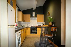 eine Küche mit gelben Schränken und einem weißen Kühlschrank in der Unterkunft WhiteGates Rows City Centre Apartment by Rework Accommodation in Chester