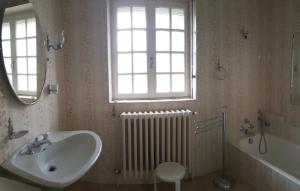 ein Badezimmer mit einem Waschbecken, einem Fenster und einem Heizkörper in der Unterkunft le relais fleuri in Alès