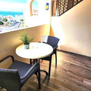 una mesa y sillas en una habitación con vistas al océano en Castle Harbour Duplex With Pool View C115 en Los Cristianos