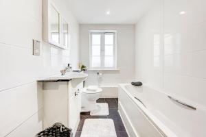 a white bathroom with a toilet and a sink at 3-Bedroom Penthouse, Brentford, Free Parking in Brentford