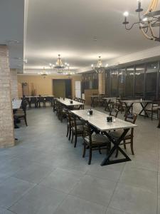 ein Esszimmer mit Tischen und Stühlen in einem Gebäude in der Unterkunft Сарканд in Proletarskiy