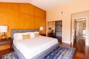 ein Schlafzimmer mit einem großen weißen Bett und Holzwänden in der Unterkunft San Jose 4br w balcony nr mall park groceries SFO-1538 in San Jose