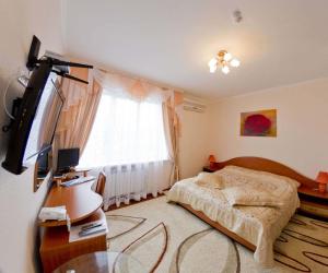 1 dormitorio con cama y ventana grande en Kristina Hotel, en Zaporozhye