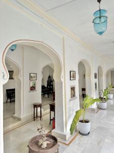 an archway in a white room with potted plants at Dev Niwas - Heritage Hotel in Būndi