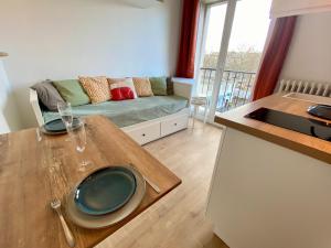 a kitchen and living room with a table and a couch at L'Escale Appartements et Suites en bord de Mer in Le Havre