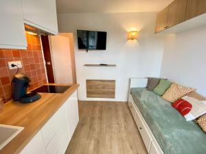 Телевизор и/или развлекательный центр в L'Escale Appartements et Suites en bord de Mer