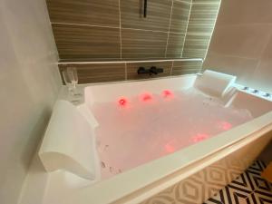 a white bath tub with red balls in it at L'Escale Appartements et Suites en bord de Mer in Le Havre