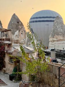 un globo de aire caliente está en el cielo sobre una ciudad en Naraca Cave House, en Göreme