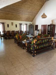 ein Wohnzimmer mit Sofas, Tischen und Stühlen in der Unterkunft Nino Ranch Lodge 