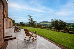 a patio with two chairs and a table on a lawn at The Sheep Fold in Melrose