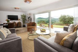 a living room with couches and a large window at The Sheep Fold in Melrose