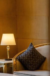 a pillow sitting on a chair next to a lamp at Historia Royal in Udaipur