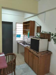 eine Küche mit einer Spüle und einer Mikrowelle in der Unterkunft Glory Beach Resort in Port Dickson
