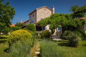 a stone house with a garden in front of it at Villa Paradiso in Umag