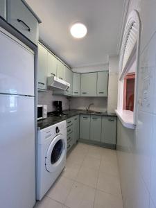 uma cozinha com uma máquina de lavar roupa e um frigorífico branco em Las Palmeras -Marbella Centro- by Completely Marbella em Marbella