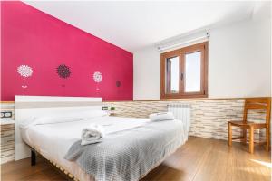 a bedroom with a large bed with a pink wall at MUNALLA-IDEAL FAMILIAS Y AMIGOS. SENDERISMO. in Aia