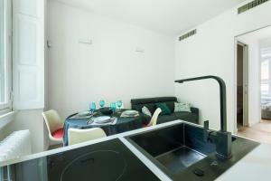 eine Küche mit einem Waschbecken und ein Wohnzimmer in der Unterkunft HL Apartment - Sant'Ambrogio, Duomo in Mailand