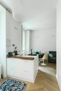 eine weiße Küche mit einem Waschbecken und ein Wohnzimmer in der Unterkunft HL Apartment - Sant'Ambrogio, Duomo in Mailand