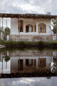 a white house with a reflection in the water at Country Road Villa in Xuyên Mộc