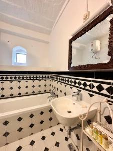 a bathroom with a sink and a tub and a mirror at Dev Niwas - Heritage Hotel in Būndi