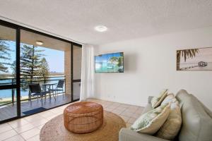 een woonkamer met een bank en een tafel bij Allamanda, Unit 11, 32 Esplanade, Bulcock Beach in Caloundra