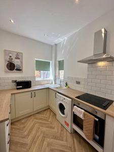 a kitchen with a washer and dryer in it at Three bedroom home Manchester, sleeps 9! in Manchester