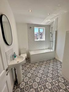 a bathroom with a sink and a tub and a toilet at Three bedroom home Manchester, sleeps 9! in Manchester