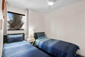een slaapkamer met 2 bedden naast een raam bij Allamanda, Unit 11, 32 Esplanade, Bulcock Beach in Caloundra