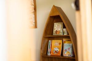 ein Bücherregal mit Büchern neben einer Wand in der Unterkunft Country Road Villa in Xuyên Mộc