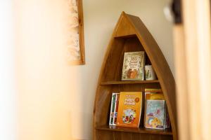 a book shelf with books on it next to a wall at Country Road Villa in Xuyên Mộc