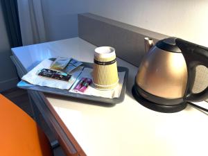 un plateau avec une lampe et d'autres articles sur une table dans l'établissement Kyriad Argenteuil, à Argenteuil