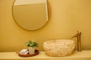 a bathroom counter with a mirror and a sink at Country Road Villa in Xuyên Mộc