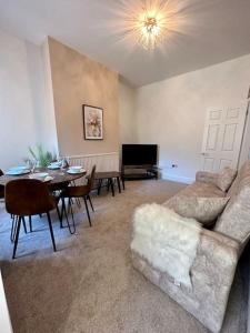 a living room with a couch and a dining room at Three bedroom home Manchester, sleeps 9! in Manchester