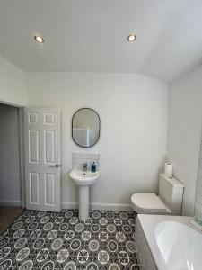 a bathroom with a sink and a toilet and a mirror at Three bedroom home Manchester, sleeps 9! in Manchester