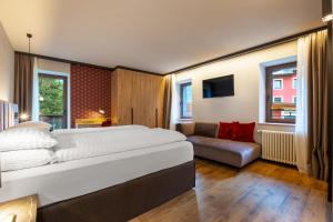 um quarto com uma cama grande e um sofá em Family Apartments Vioz em Peio Fonti