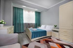 1 dormitorio con 1 cama y una ventana con cortinas verdes en ЖК Айгерим, en Almaty