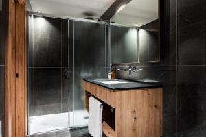 uma casa de banho com um lavatório e um chuveiro em Family Apartments Vioz em Peio Fonti