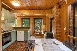 a kitchen with a table and chairs in a room at Cabin by the river with Sauna in Polhov Gradec