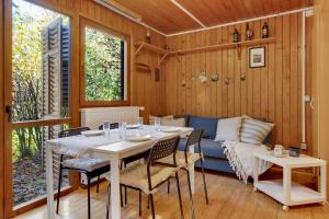 a dining room with a table and a couch at Cabin by the river with Sauna in Polhov Gradec