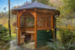 a wooden gazebo with a table in it at Cabin by the river Polhov Gradec in Polhov Gradec +18 photos