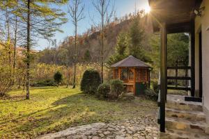 a gazebo on the side of a house at Cabin by the river with Sauna in Polhov Gradec