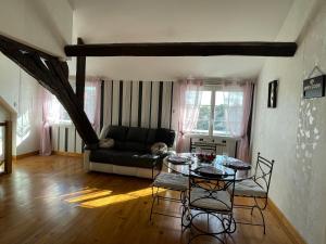een woonkamer met een bank en een tafel bij Appart' Privé à Issoudun : Confort et Style in Issoudun