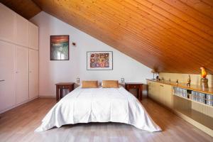 1 dormitorio con cama grande y techo de madera en Preciosa casa cerca de la playa, en Castelldefels